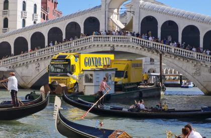 Yellow trucks navigate the Grand Canal: a spectacular Gondrand removal